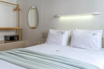 a bedroom with a bed with white sheets and pillows at LOFUS Bio-Suites in Athens
