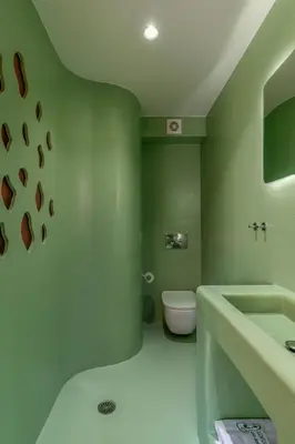 a green bathroom with a toilet and a sink at LOFUS Bio-Suites in Athens