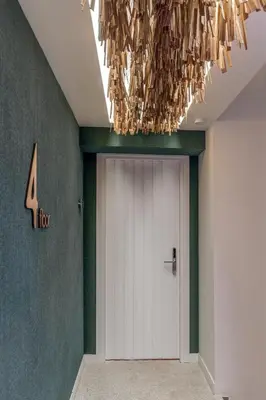 a hallway with a white door and a chandelier at LOFUS Bio-Suites in Athens