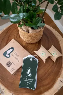 a wooden table with a potted plant and two tags at LOFUS Bio-Suites in Athens