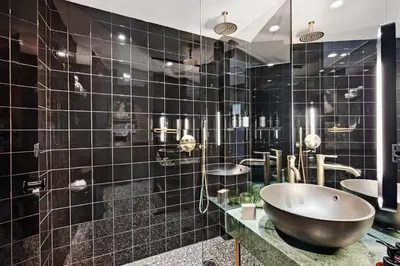 a bathroom with black tiled walls and a large tub at Skylark, Aluma Hotels & Resorts in Athens