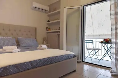a bedroom with a bed and a sliding glass door at Glyfada's House Project! in Athens