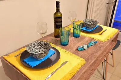 a table with two plates and a bottle of wine at Glyfada's House Project! in Athens