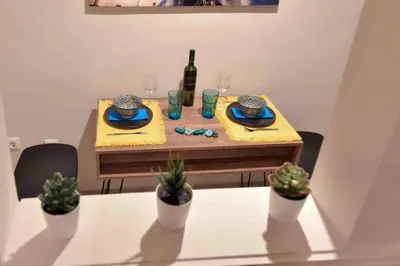 a dining room table with a bottle of wine and plants at Glyfada's House Project! in Athens