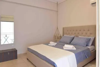 a bedroom with a bed with two towels on it at Glyfada's House Project! in Athens