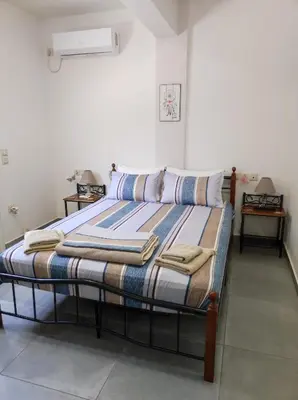 a bed in a room with two pillows on it at PHOENIX apartment near the airport in Markopoulo