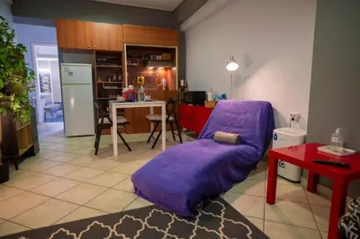 a living room with a purple couch and a kitchen at 