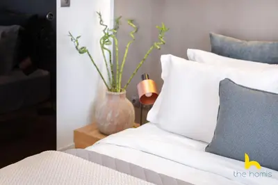 a bedroom with a bed and a vase with flowers at Urban Views, Modern Apartment In The Heart of Athens in Athens