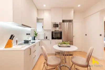 a kitchen with white cabinets and a table and chairs at Urban Views, Modern Apartment In The Heart of Athens in Athens