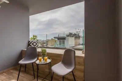 a balcony with two chairs and a table with drinks on it at Raise Athens Metro Apartments in Athens