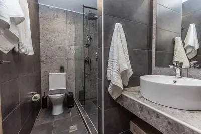 a bathroom with a sink and a toilet and a shower at Raise Athens Metro Apartments in Athens