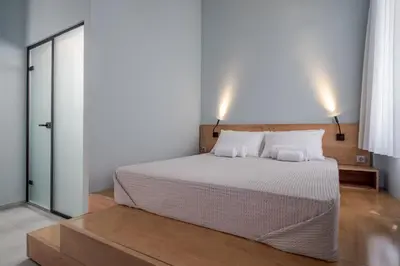 a bedroom with a white bed with two pillows at Twin Circle Athens in Athens
