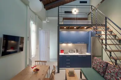 a kitchen with a wooden table and a spiral staircase at Twin Circle Athens in Athens