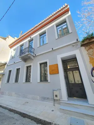 a white house with a black door at Twin Circle Athens in Athens