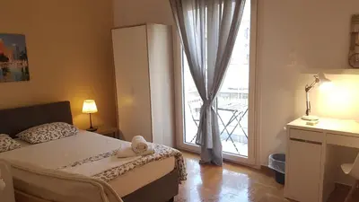 a bedroom with a bed and a large window at Petrol Apartment- Athens Center, 4 BD, 1 BATH in Athens