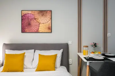 a bedroom with a bed with yellow pillows and a table at Trikoupi 95 in Athens
