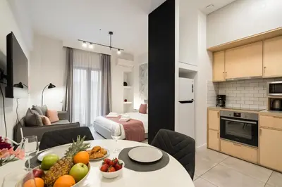 a kitchen and a living room with a table with fruit at Trikoupi 95 in Athens