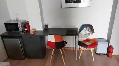a black desk with two chairs and a microwave at METROPOLITAN MACVIEW-3 διαμέρισμα studio Φάληρο in Piraeus