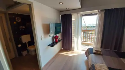 a bedroom with a view of a room with a window at METROPOLITAN MACVIEW-3 διαμέρισμα studio Φάληρο in Piraeus