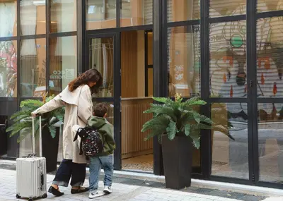 a woman and a child standing in front of a store at Vasi in Athens