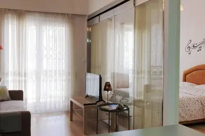 a living room with a bed and a glass wall at Ground floor apt with rooftop and stunning view in Athens