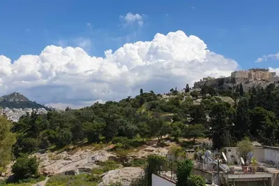 a view of a mountain with clouds in the sky at Ground floor apt with rooftop and stunning view in Athens