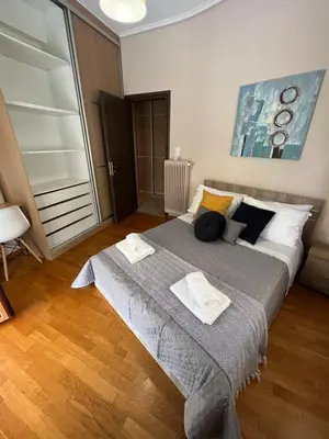 a bedroom with a large bed with two towels on it at Alimos Cozy Getaway, close to the beach in Athens