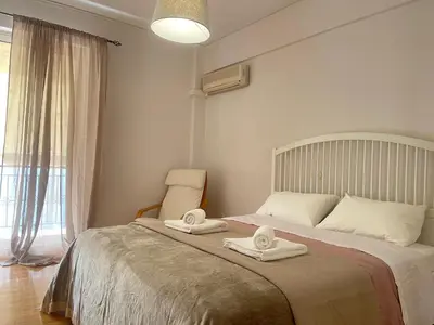a bedroom with a bed with two towels on it at Cassiopeia - Glyfada Apartment in Athens