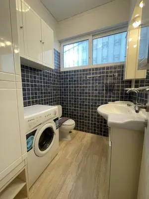 a bathroom with a washing machine and a sink at Cassiopeia - Glyfada Apartment in Athens