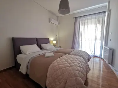 a bedroom with a large bed with a large window at Cassiopeia - Glyfada Apartment in Athens