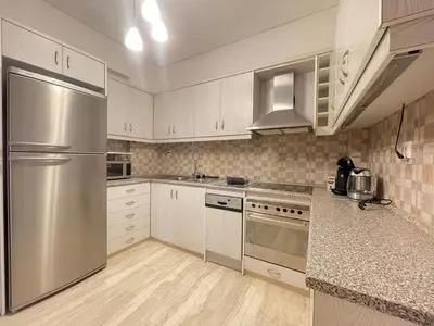 a kitchen with white cabinets and stainless steel appliances at Cassiopeia - Glyfada Apartment in Athens