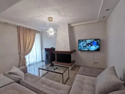 a living room with a couch and a fireplace at Cassiopeia - Glyfada Apartment in Athens