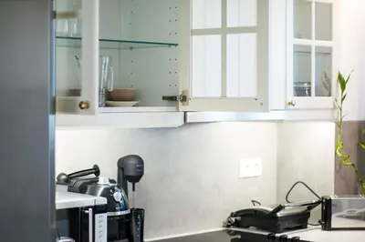 a kitchen with white cabinets and a sink at Marina's Luxury Apartment close to Acropolis in Athens