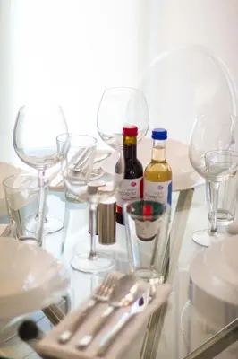 a glass table with wine bottles and glasses on it at Marina's Luxury Apartment close to Acropolis in Athens