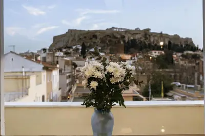 a vase filled with white flowers sitting on a ledge at The Prestige Acropolis Penthouse in Athens
