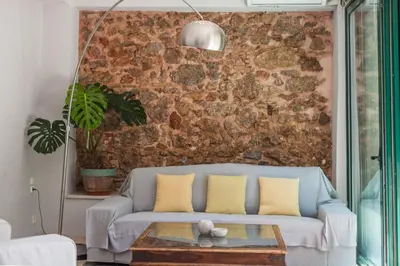 a living room with a couch and a brick wall at Athenian Yard Near Acropolis in Athens