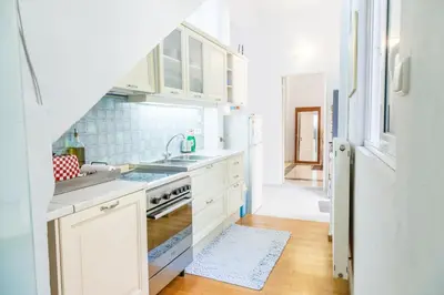 a kitchen with white cabinets and a sink at Athenian Yard Near Acropolis in Athens