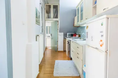 a kitchen with white appliances and a wooden floor at Athenian Yard Near Acropolis in Athens