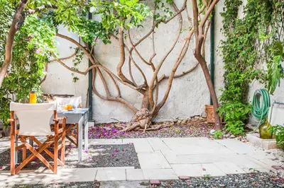a table and chairs in front of a tree at Athenian Yard Near Acropolis in Athens