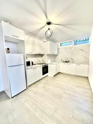 a kitchen with white cabinets and a white refrigerator at The Aegean Nest in Athens