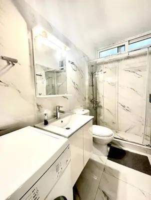 a white bathroom with a sink and a toilet at The Aegean Nest in Athens
