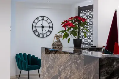 a dining room with a table and a clock on the wall at Evita Asty in Athens