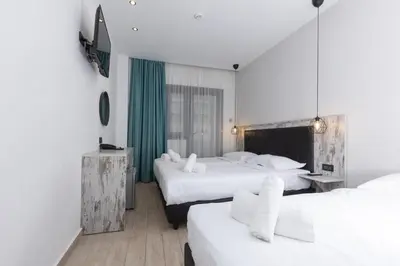 a hotel room with two beds with white sheets at Evita Asty in Athens