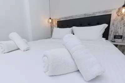 a bedroom with two white beds with towels on them at Evita Asty in Athens