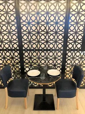 a table and chairs in a room with a wall at Evita Asty in Athens