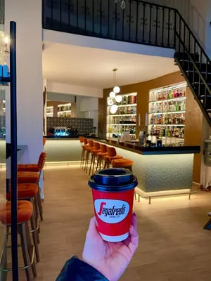 a person holding a cup of coffee in a restaurant at Evita Asty in Athens
