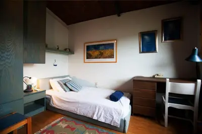a bedroom with a bed and a desk and a chair at villa eleni in Sounio