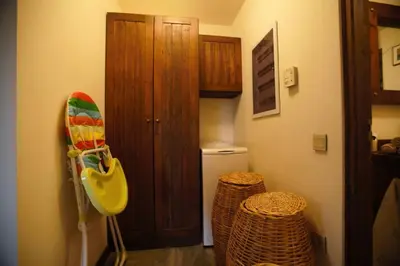 a bathroom with a wooden door and two wicker stools at villa eleni in Sounio