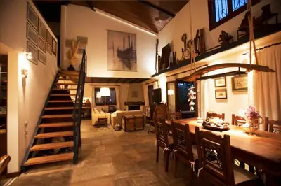 a living room with a staircase and a table and chairs at villa eleni in Sounio