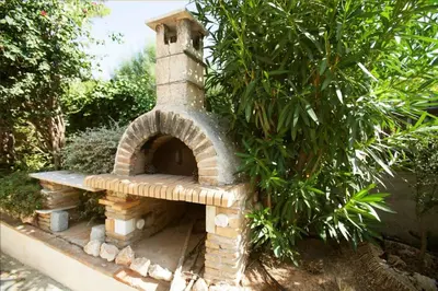 a brick oven sitting next to a tree at villa eleni in Sounio